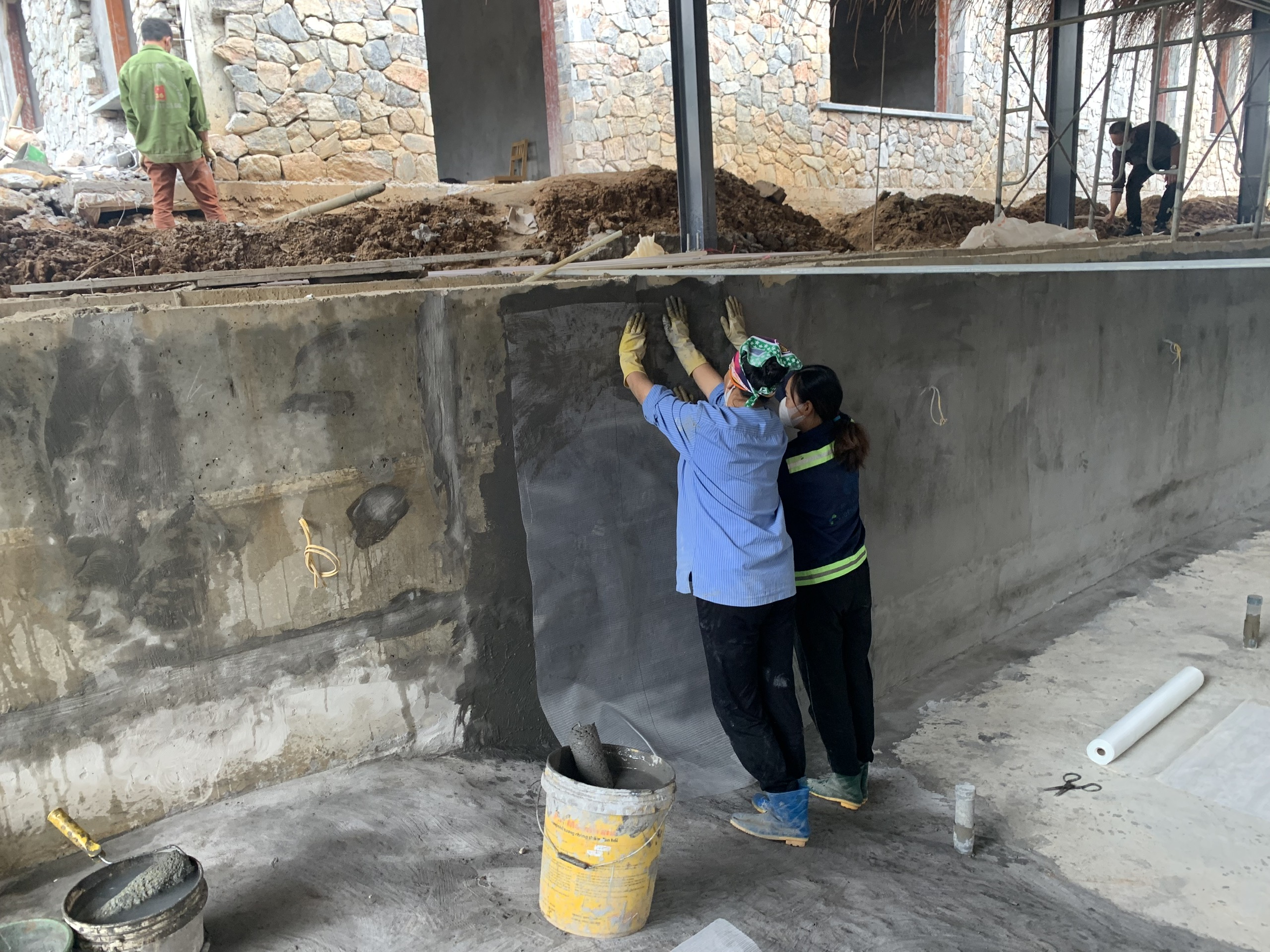 nhân công đang làm chống thấm tại bể bơi